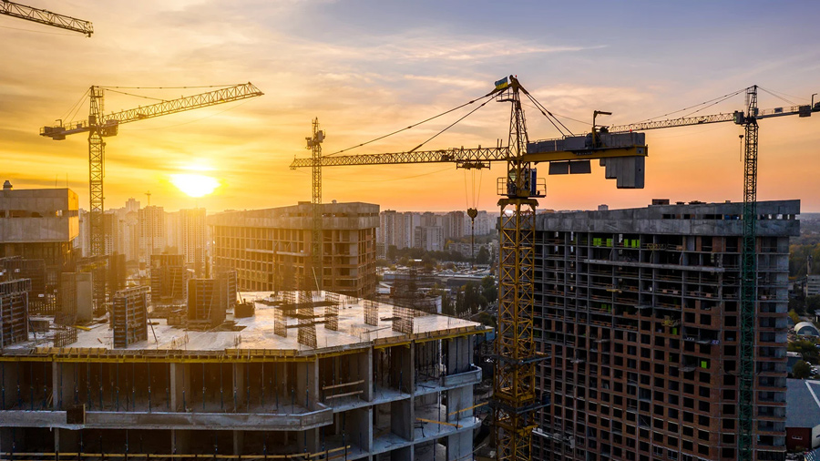 Construction site with cranes at sunset