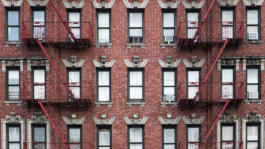 view of red apartment building from the street