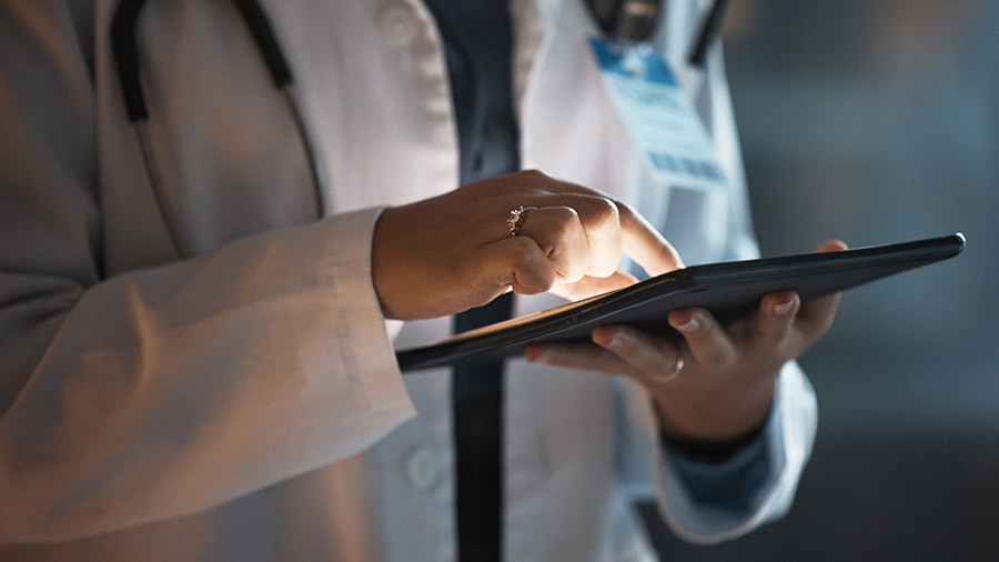 close up of doctor using a tablet in a dimly lit hospital room.jpg