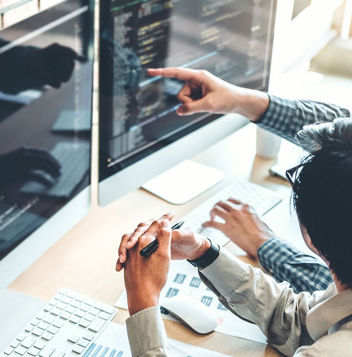 two people reviewing code on computer