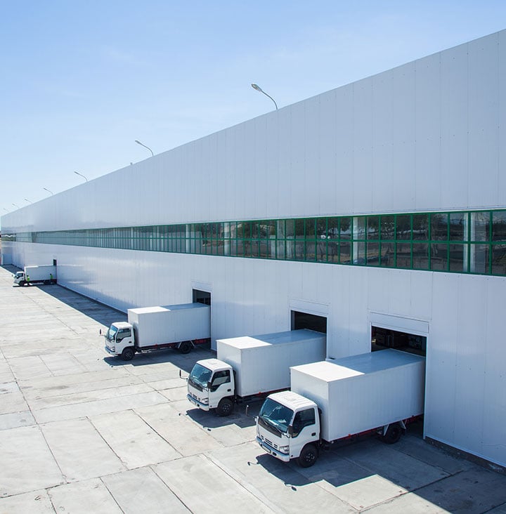 large industrial building with trucks backed up to loading docks